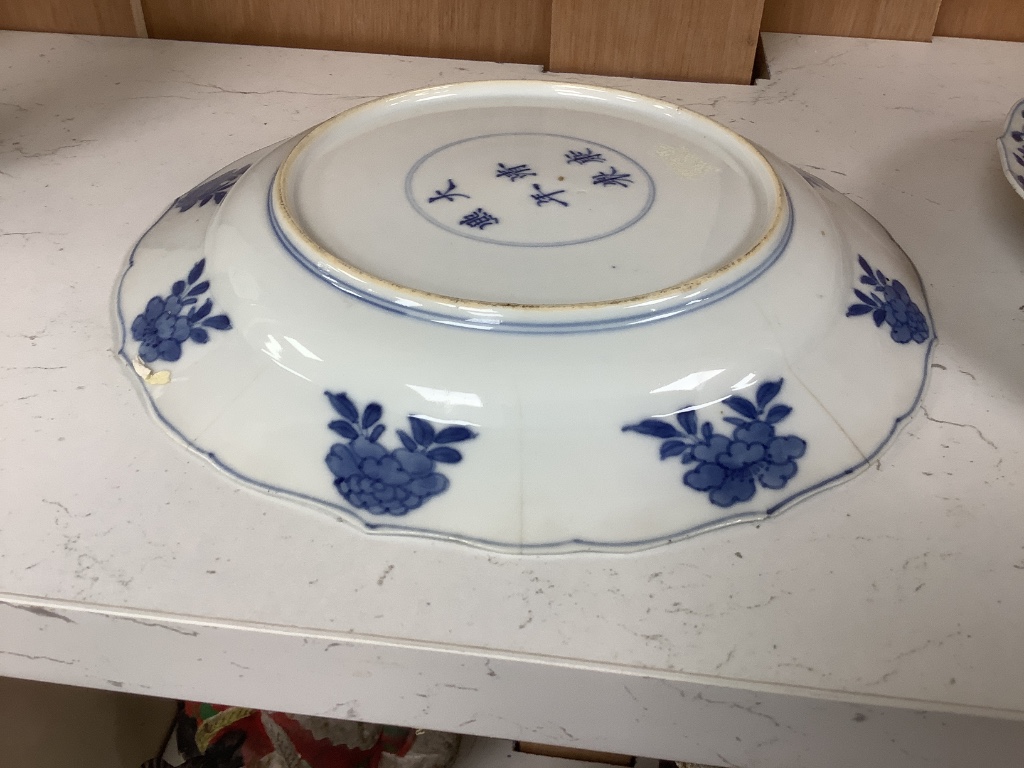 A pair of Chinese blue and white porcelain plates, Kangxi mark and period, with shaped borders and floral motifs, diameter 20cm